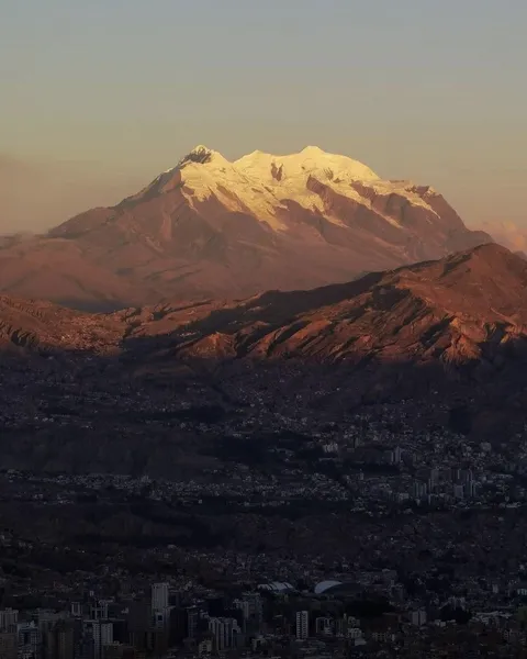 The Illimani lit by the evening sun above La Paz