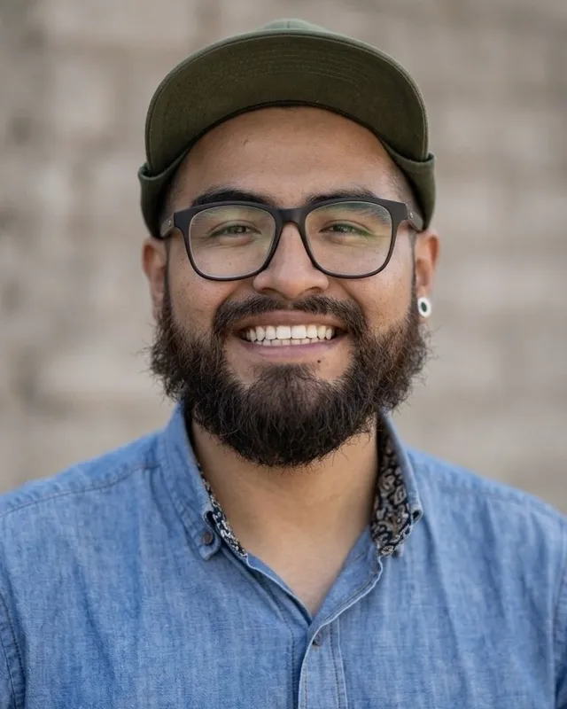 Jeffry Soria, founder of Fat Cat Valle de las Animas Tours, smiling in a green cap and denim shirt