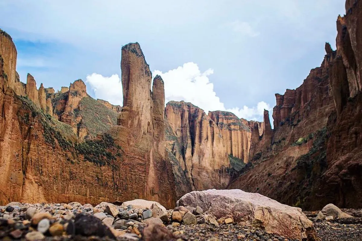 Palca Canyon: red rock walls and stone towers above the dry riverbed