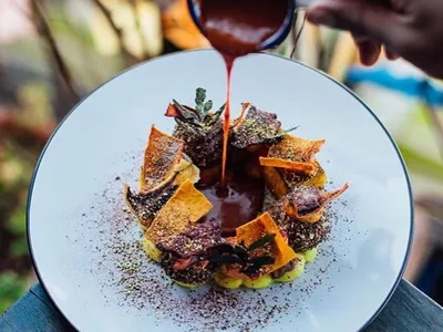 Bolivian cuisine in La Paz: a chef pours sauce over a plate