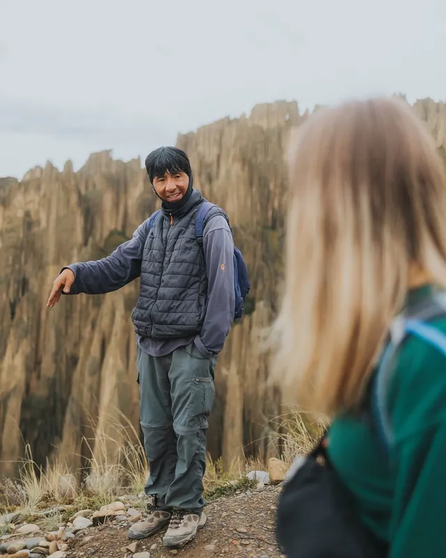 A Fat Cat guide explaining the valley to a traveler, spires behind