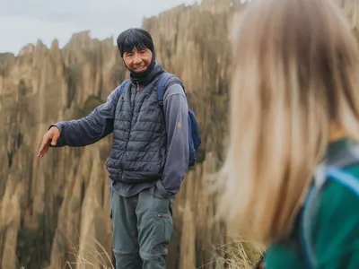 A guide explaining the valley to a traveler
