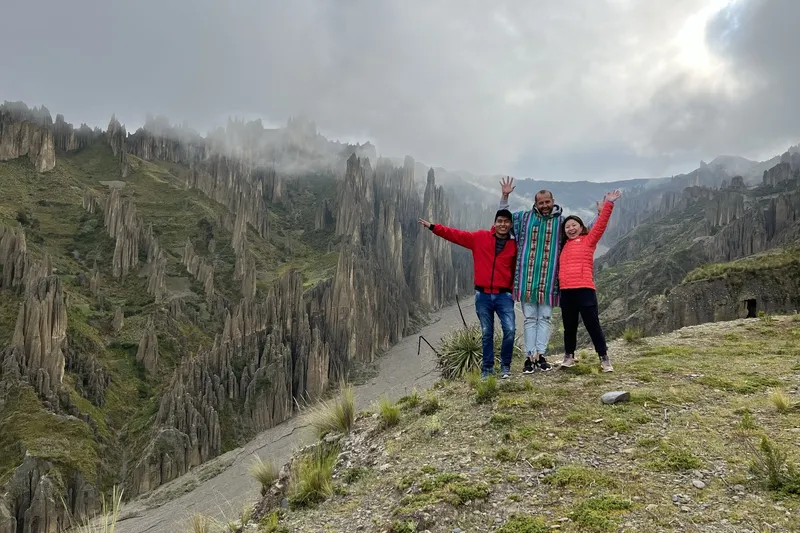 A group jumping for a photo on the ridge, the valley behind