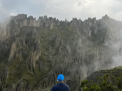 A traveler walking among the spires of Valle de las Ánimas in the mist