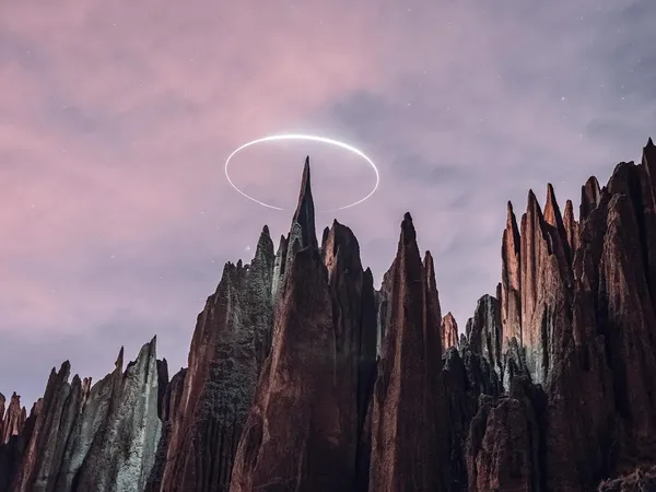 The spires at dusk under a pink sky, a ring of light above the tallest one