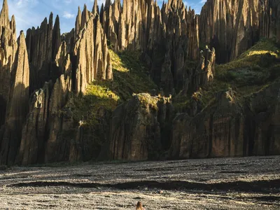 A hiker dwarfed by the spires at the bottom of the valley