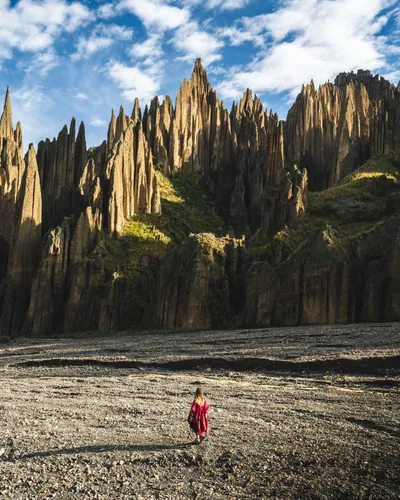 A hiker dwarfed by the spires at the bottom of the valley