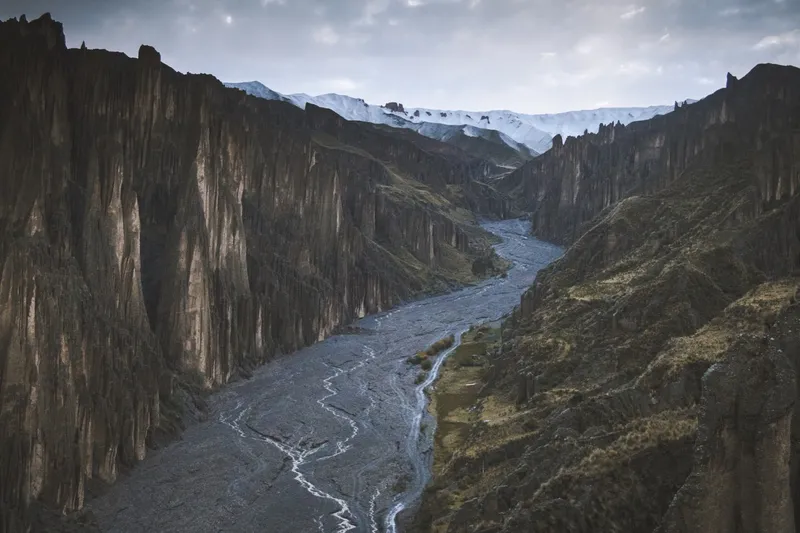 The dry riverbed winding between two walls of spires