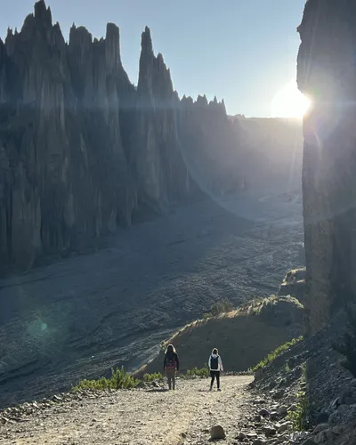 Sunrise: the sun breaking over the spires, a hiker in silhouette